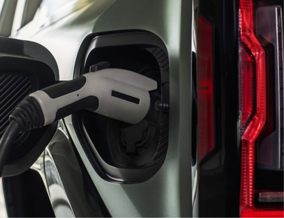 Close up of charging port with charger plugged in on a GMC Hummer EV SUV - Alexander GMC in OXNARD CA